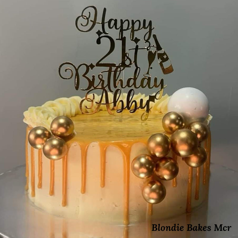 A beautiful 'Happy 21st Birthday' golden cake topper sits on top of a delicious cake baked by Blondie Bakes Mcr.